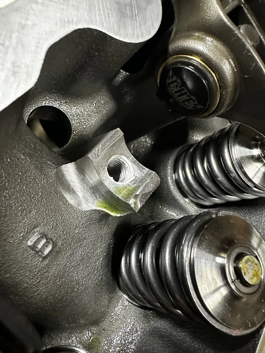 Ported Gen V cylinder head showing a threaded boss opened by machining